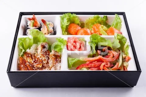 Fresh food portion in japanese bento box with salad, main course. Sushi roll Stock Photos