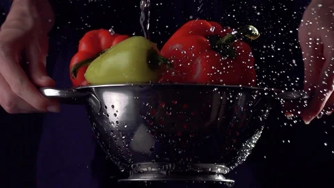 Fresh food. Super slow motion. Hands holding a colander with vegetables under a Stock Footage 115836053