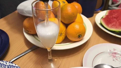 Fresh fruit and empty glass on wooden table with plates and food at gathering in Stock Footage 325794333