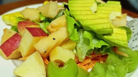 Fresh fruit and vegetable salad topped with sliced avocado. Vidéo 345292283