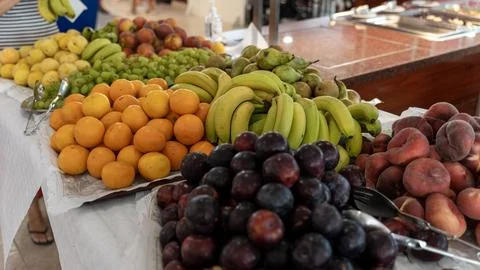 Fresh Fruit Buffet Display with Bananas Oranges Plums Peaches and Grapes Stock Photos