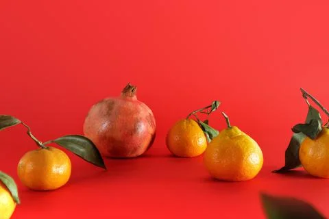 Fresh fruit composition on red background. Natural tangerines with green leaves Stock Photos