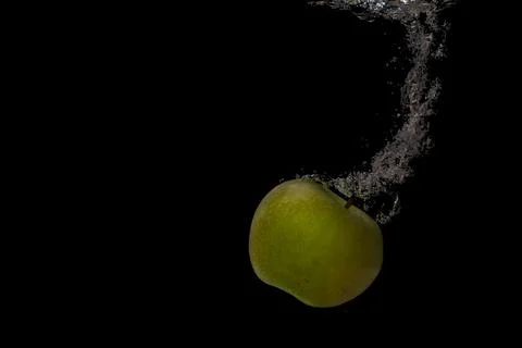 Fresh fruit fall into the cold water with air bubbles healthy vegan lifestyle Stock Photos