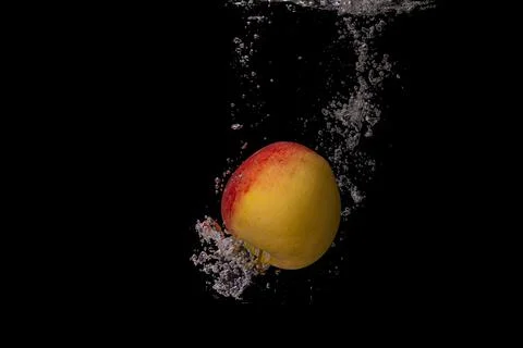 Fresh fruit fall into the cold water with air bubbles healthy vegan lifestyle Stock Photos