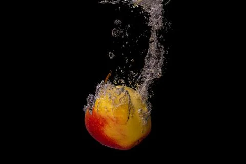Fresh fruit fall into the cold water with air bubbles healthy vegan lifestyle Stock Photos