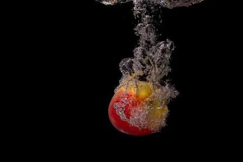 Fresh fruit fall into the cold water with air bubbles healthy vegan lifestyle Foto stock