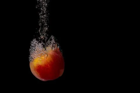 Fresh fruit fall into the cold water with air bubbles healthy vegan lifestyle Stock-Fotos