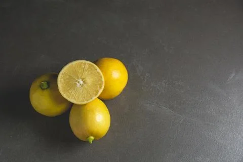 Fresh fruit lemons with lemon slice on black table background. Stock Photos