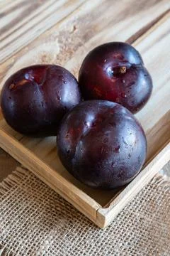Fresh fruit plums on rustic background Stock Photos