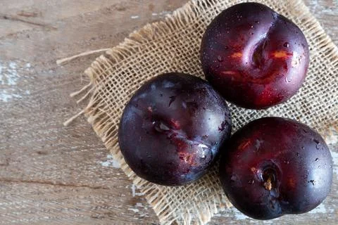 Fresh fruit plums on rustic background Stock Photos