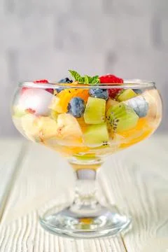 Fresh fruit salad on a background of a light brick wall Stock Photos