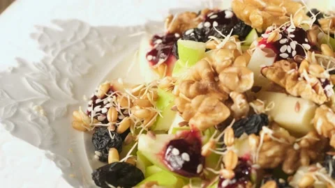 Fresh fruit salad with nuts, raisins and wheat germ. vegetarian healthy food Stock Footage 219475033