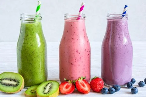 Fresh fruit smoothies or milkshake in glass bottles with fresh berries and .. Stock Photos