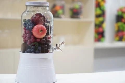Fresh Fruits Apple and grape inside a dispenser glass jar. Healthy Food Lifes Stock Photos