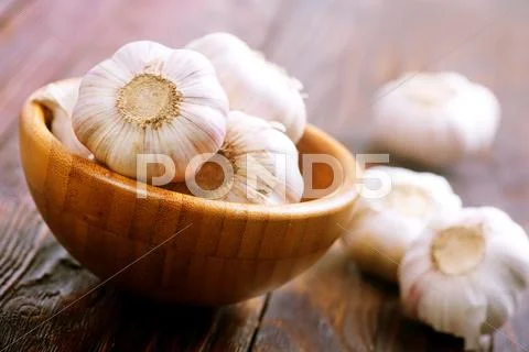 Fresh garlic in bowl on a table Stock Photos