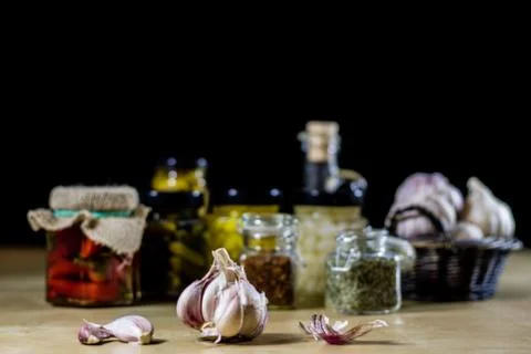 Fresh garlic smelling on the kitchen table. Mortar and kitchenware. Wooden ta Stock Photos