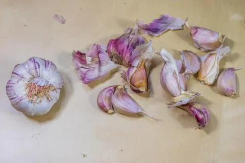 Fresh garlic smelling on the kitchen table. Mortar and kitchenware. Wooden ta Stock Photos