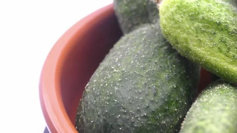 Fresh gherkins rotating in deep plate on white background Stock Footage 342984774
