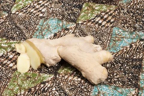 Fresh ginger on a batik table cloth. Stock Photos