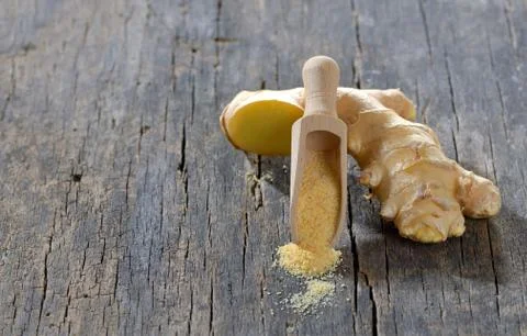 Fresh ginger root and ground ginger spice on wooden background Stock Photos