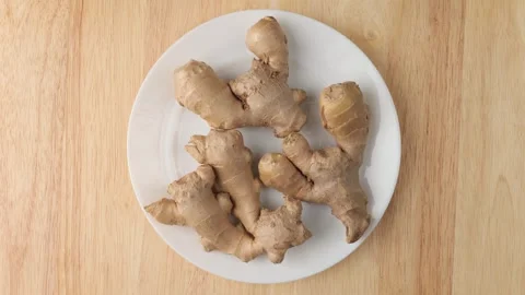 Fresh ginger root rotating on a plate Stock Footage 343435228