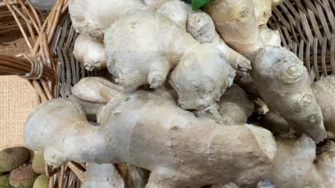 Fresh ginger roots piled in a wicker basket at a market for sale background Stock Footage 341351858