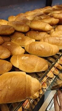 Fresh Golden Bread Rolls Displayed on Bakery Shelf with Rustic Homemade Style Stock Photos