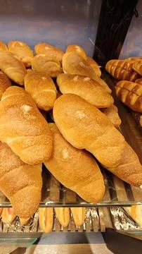 Fresh Golden Bread Rolls Displayed on Bakery Shelf with Rustic Homemade Style Stock Photos