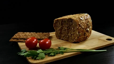 Fresh grain bread, ripe cherry tomatoes and bread crips with parsley Stock Footage 99655039