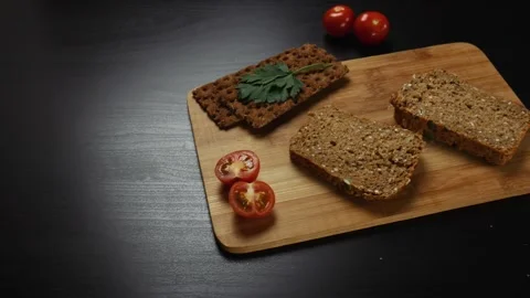 Fresh grain bread,  ripe cherry tomatoes and bread crips with parsley Stock Footage 99655803