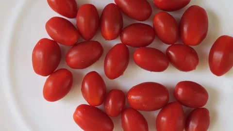 Fresh grape tomatoes rotating on white plate Vídeo Stock 336464583