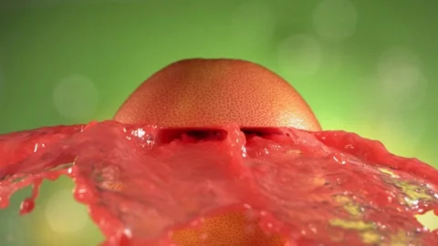 Fresh Grapefruit fruit squirting and burst with juice in slow motion in green Stock Footage 205601989