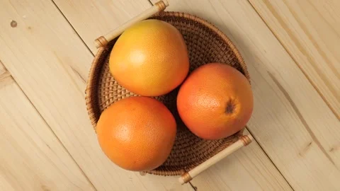Fresh grapefruits in wicker basket rotating Stock Footage 340159849