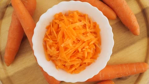 Fresh grated carrot salad rotating on wood Stock Footage 337441263