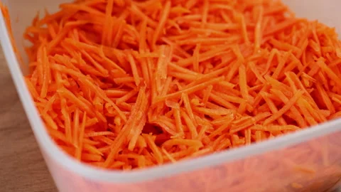 Fresh grated carrots in a plastic container Stock Footage 311588604