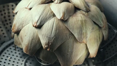 Fresh green artichoke steaming inside a metal pot insert Stock Footage 339383297