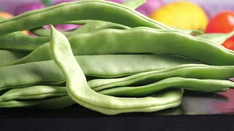 Fresh green beans on a black surface with other vegetables Stock Footage 339997781