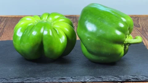 Fresh green bell peppers on a black slate flat plate 動画素材 339793473