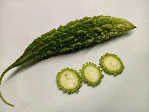 Fresh green bitter melon with three round slices isolated on white background 库存照片