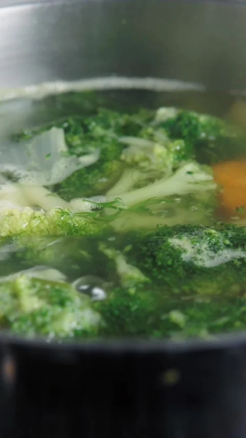 Fresh green broccoli florets boiling in cooking pot with vegetables Stock Footage 346397025