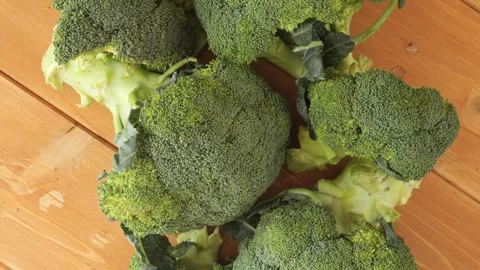 Fresh green broccoli florets rotating on a wooden table Stock-Footage 341280811