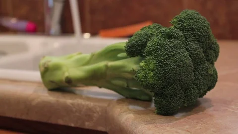Fresh Green Broccoli On Kitchen Counter Top With Running Water in Background Video stock 100575222
