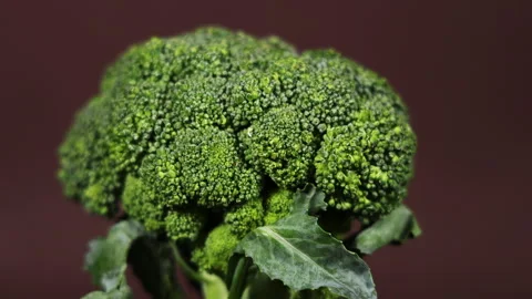 Fresh green broccoli rotating on a brown background Stock Footage 252655492