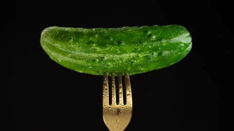 Fresh green cucumber on fork, isolated on black background Video stock 246742436