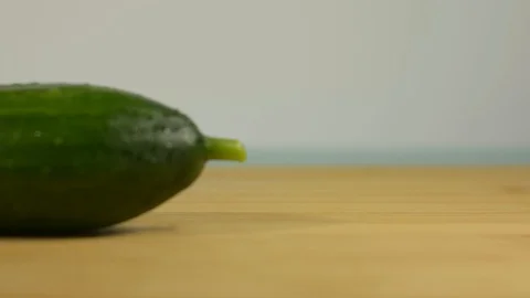 Fresh green cucumber on the kitchen table. Blurred background Stock Footage 128917783