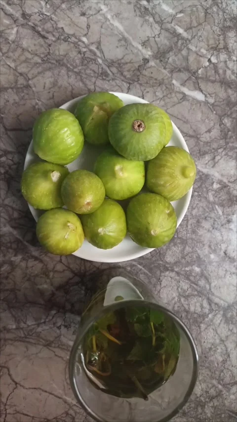 Fresh green figs on a plate next to a glass of traditional Moroccan mint tea Stock Footage 344740401