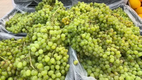 Fresh green grapes piled in boxes at market stall for sale. Ripe fruit Video stock 342438098