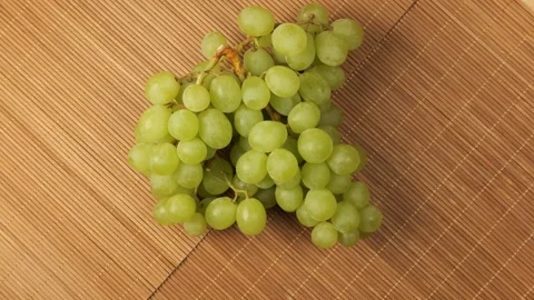 Fresh green grapes rotating on a bamboo surface Stock Footage 343435429