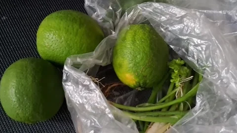 Fresh green limes and spring onions inside plastic video animation clip Stock Footage 339248272