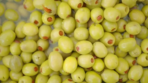 Fresh green olives stuffed with red peppers in brine top view motion shot f.. Stock Footage 332031863